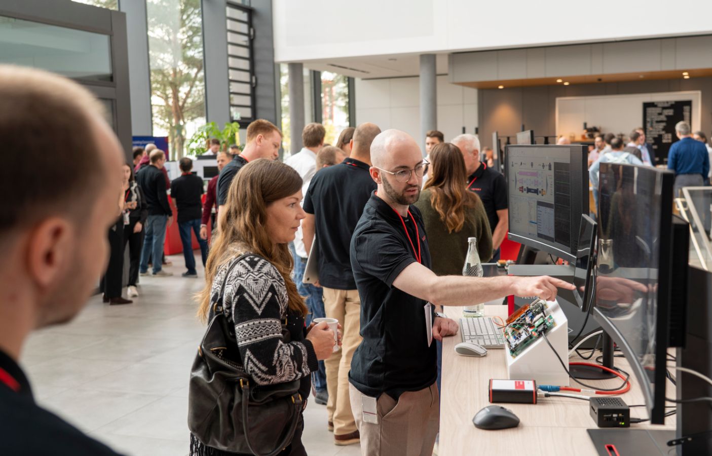 Intense Discussisons at the Vector Medical Engineering Symposium Mario Winkler demonstrating the SIL-/HIL-concept the ECG exhibit.